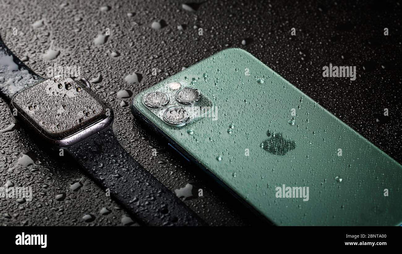 Apple Watch and iPhone 11 Pro with water drops Stock Photo