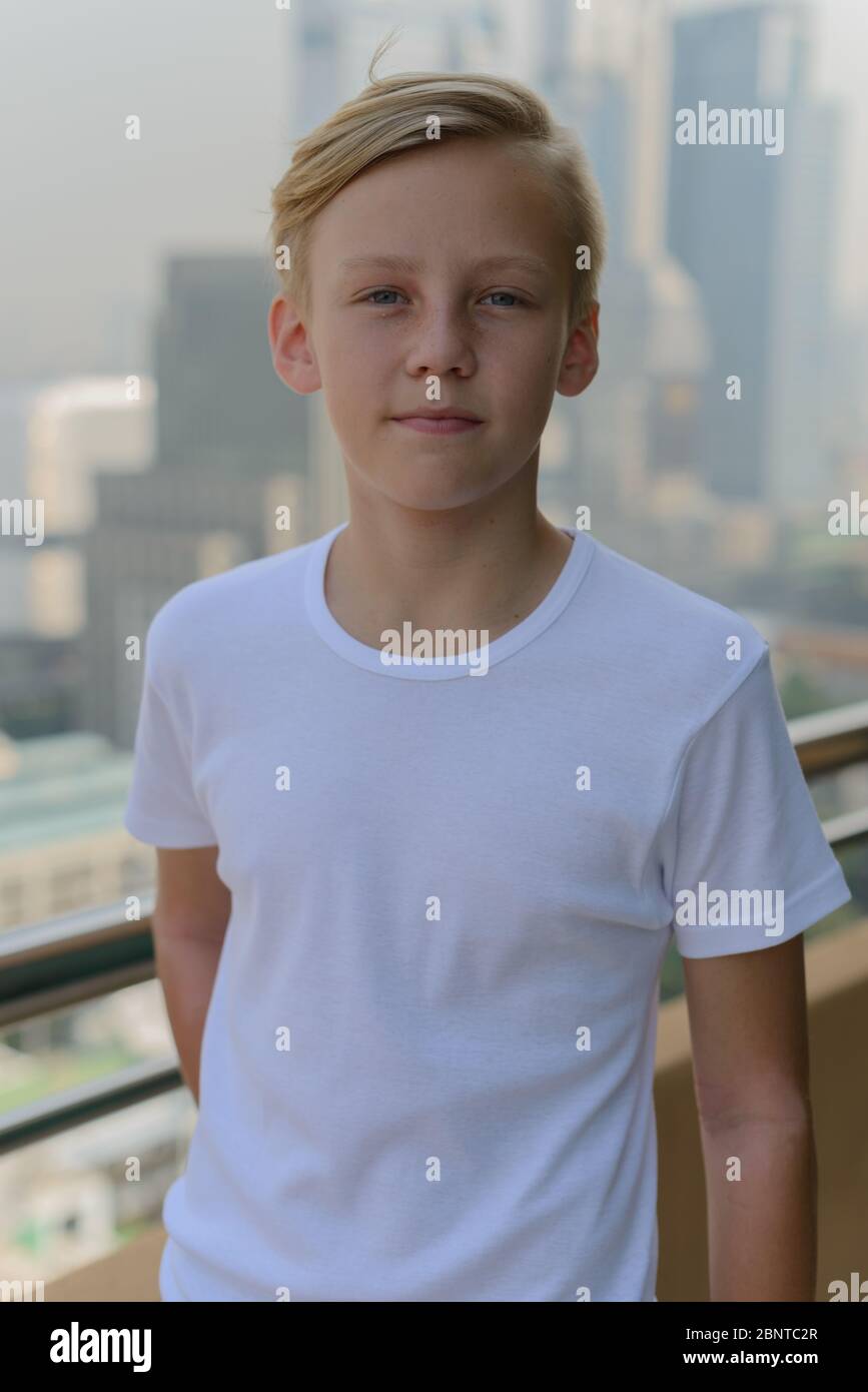 Young handsome boy with blond hair against view of the city Stock Photo ...