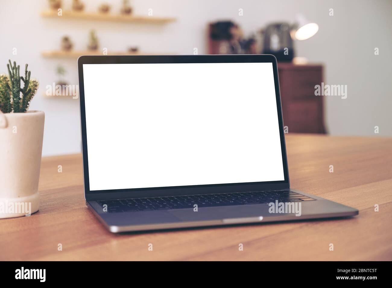 Mockup image of laptop with blank white desktop screen on wooden table ...