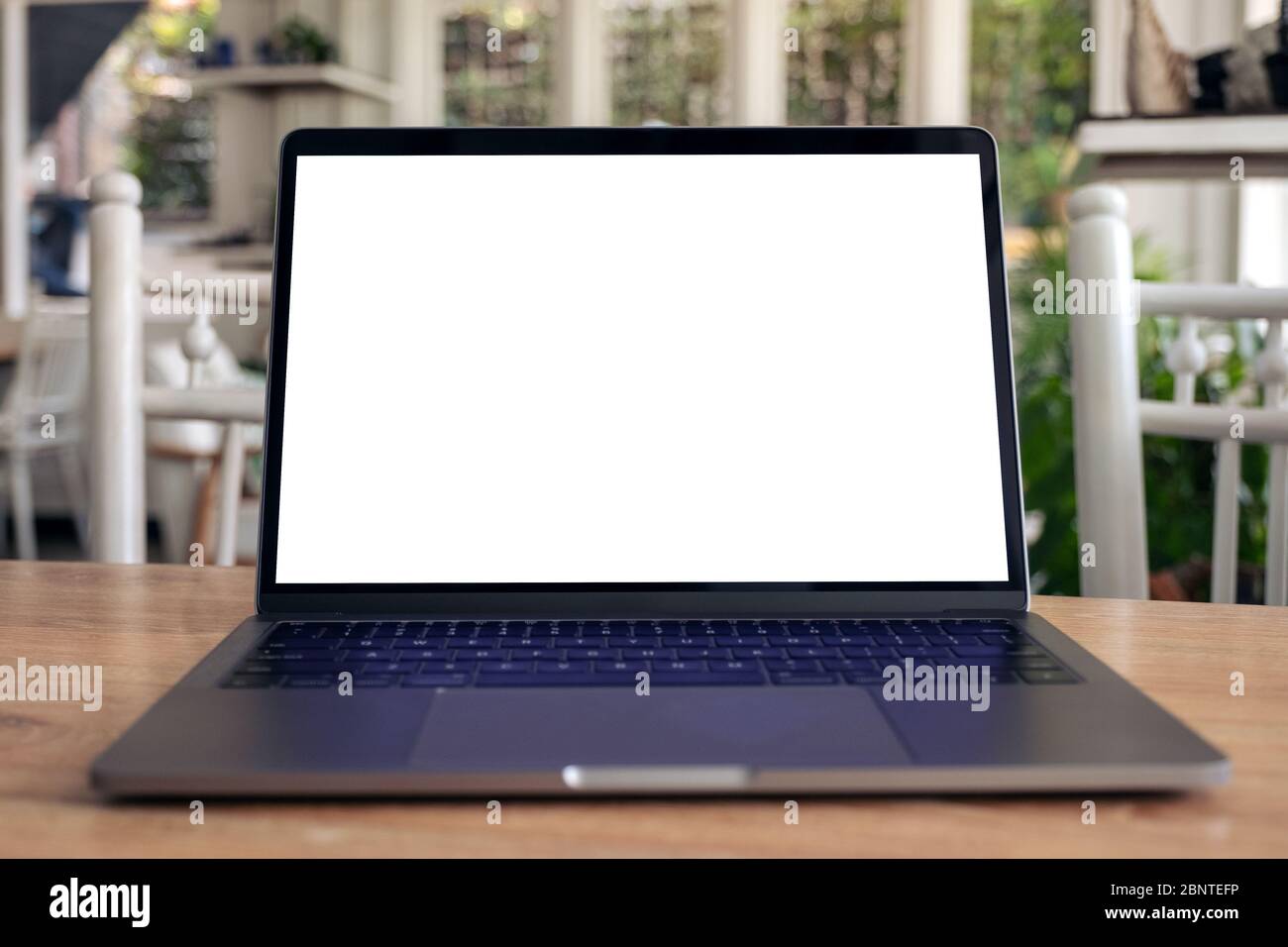 Mockup image of laptop with blank white desktop screen on wooden table ...