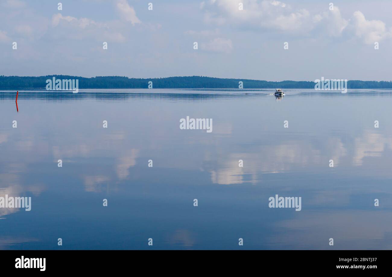 Travelers at distant motorboat at Lake Pohjois-Konnevesi at Summer , Finland Stock Photo