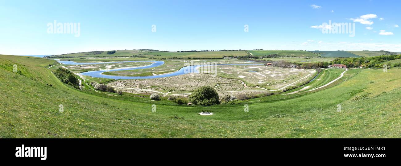 Panoramic view of the estuary of the river Cuckmere at Cuckmere Haven showing the iconic meandering S shaped river bend cutting through flood plains. Stock Photo