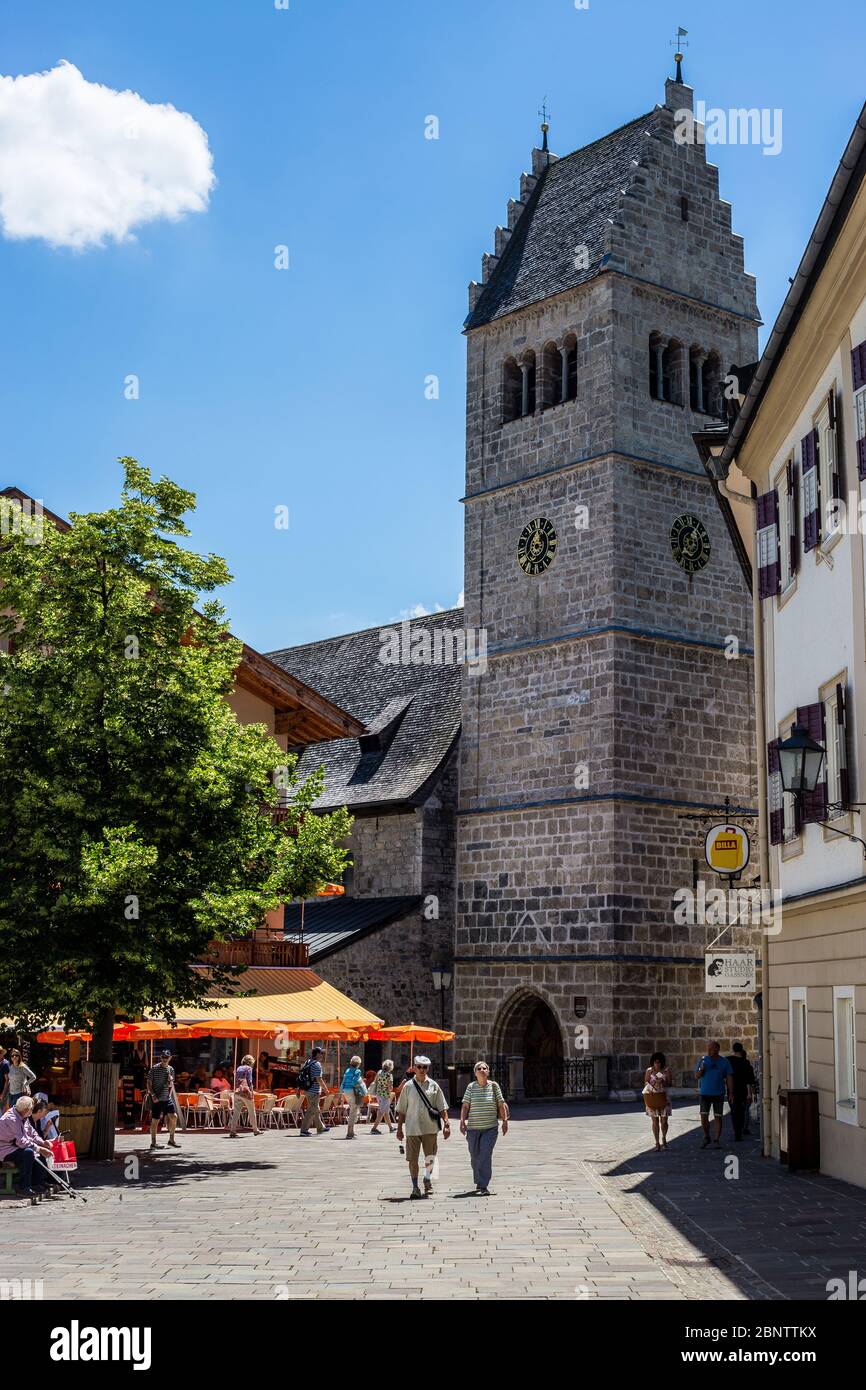 Zell am See, Austria - June 20, 2018: People Walking in the Old Town with St. Hippolyte's Church in the Background Stock Photo