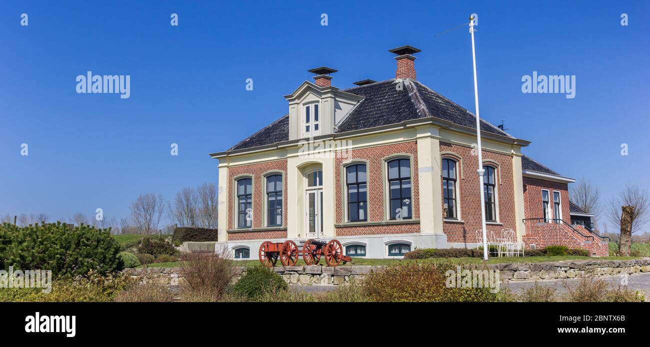 Panorama of historic cannons in front of an old house in Zoutkamp, Netherlands Stock Photo