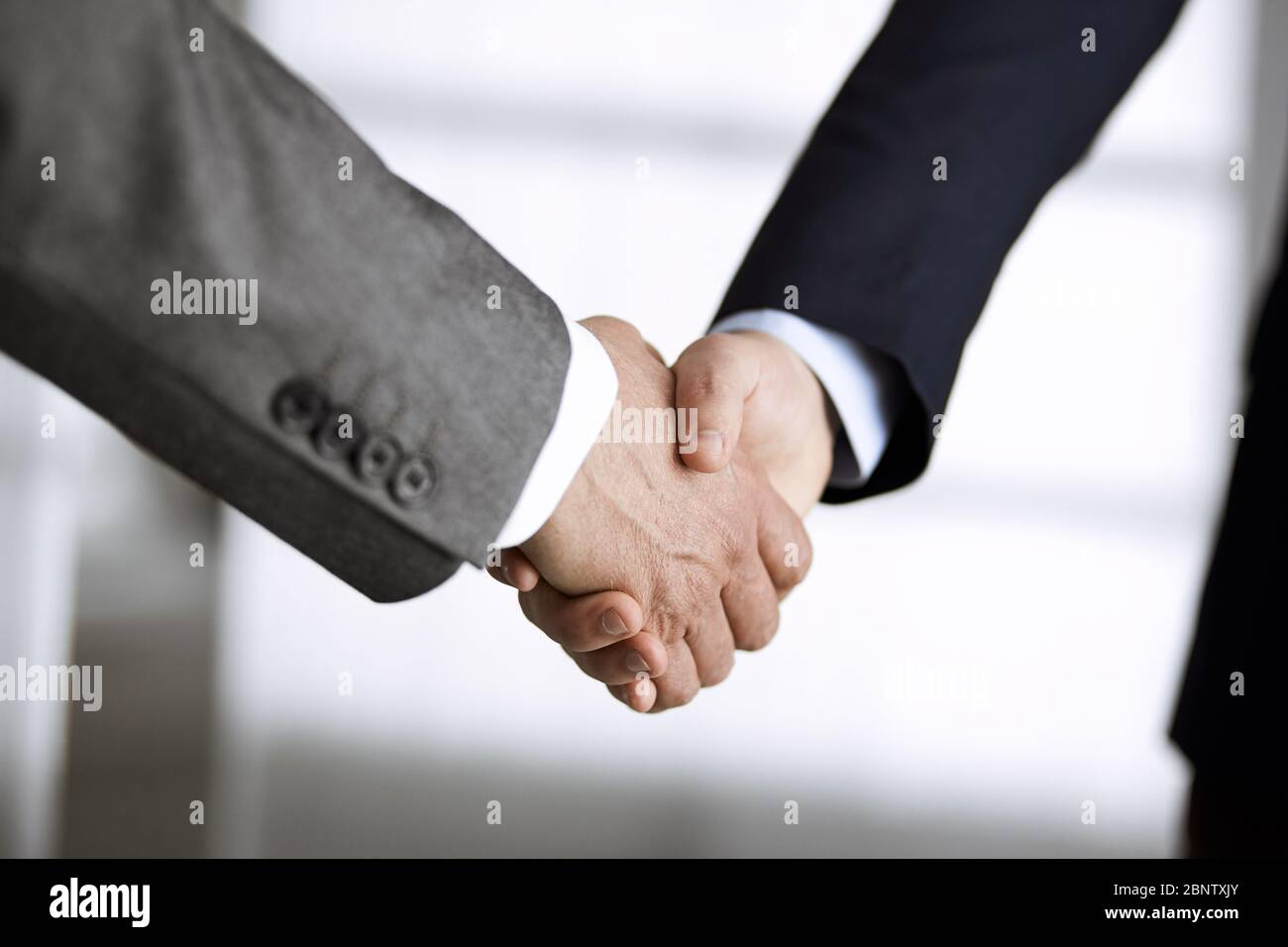 Business people in office suits standing and shaking hands, close-up. Business communication concept. Handshake and marketing Stock Photo