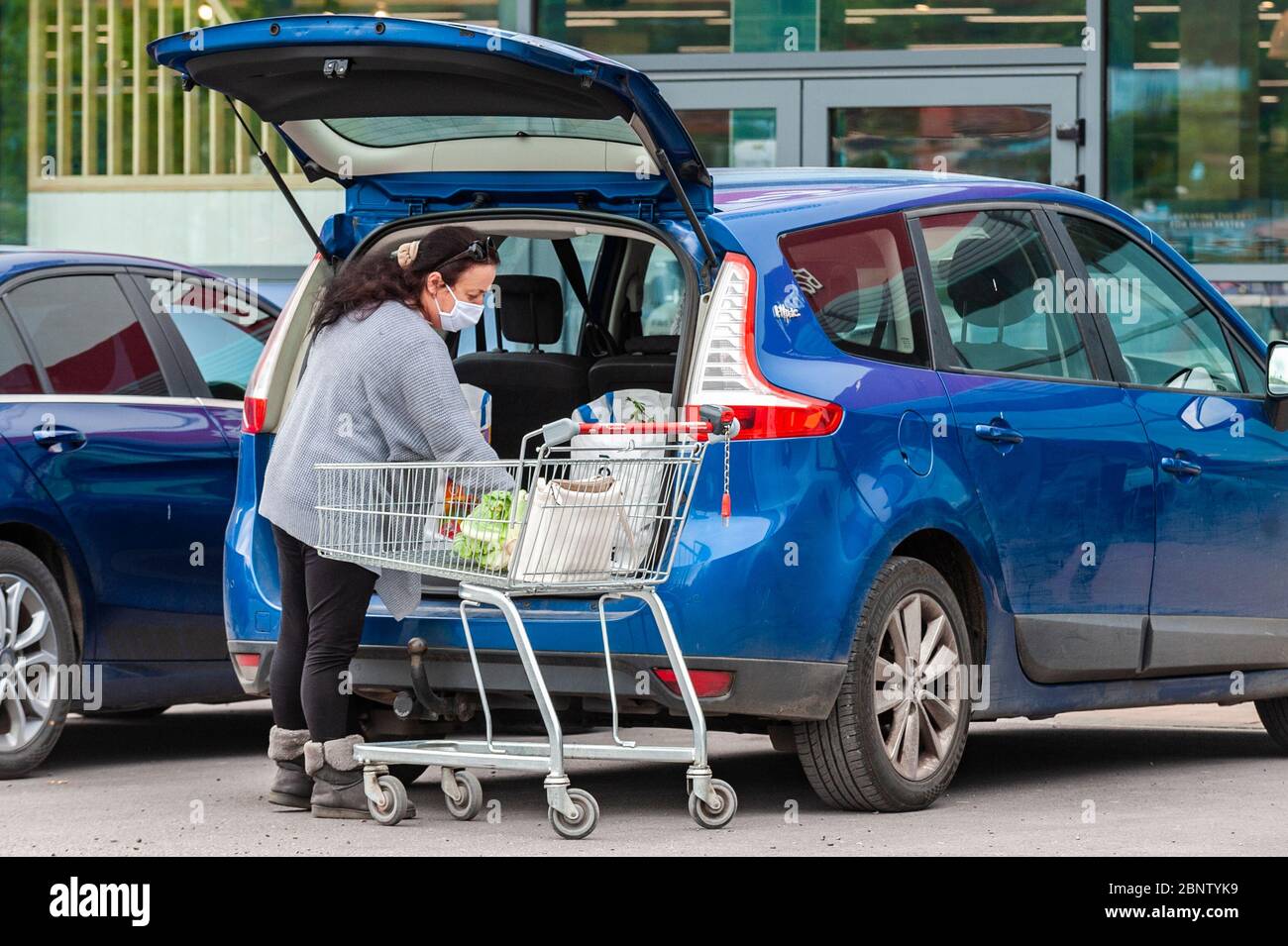 Bantry, West Cork, Ireland. 16th May, 2020. A woman wearing a face mask to protect herself from Covid-19 loads her car after a shopping trip to SuperValu supermarket in Bantry. Credit: AG News/Alamy Live News Stock Photo