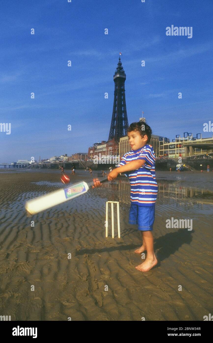 A child playing beach cricket on the beach at Blackpool, Lancashire, England, UK Stock Photo