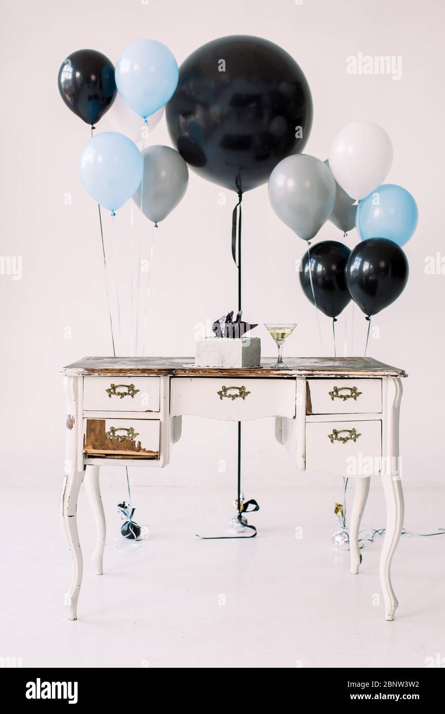 Vintage white wooden table with closets, birthday cake, martini glass