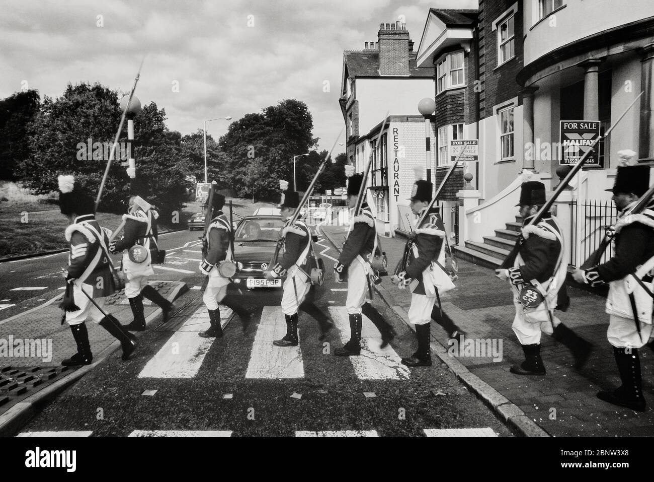 Foot soldiers from the Napoleonic war reenactment period walking across a zebra crossing. Tunbridge Wells, Kent, England, UK. Stock Photo
