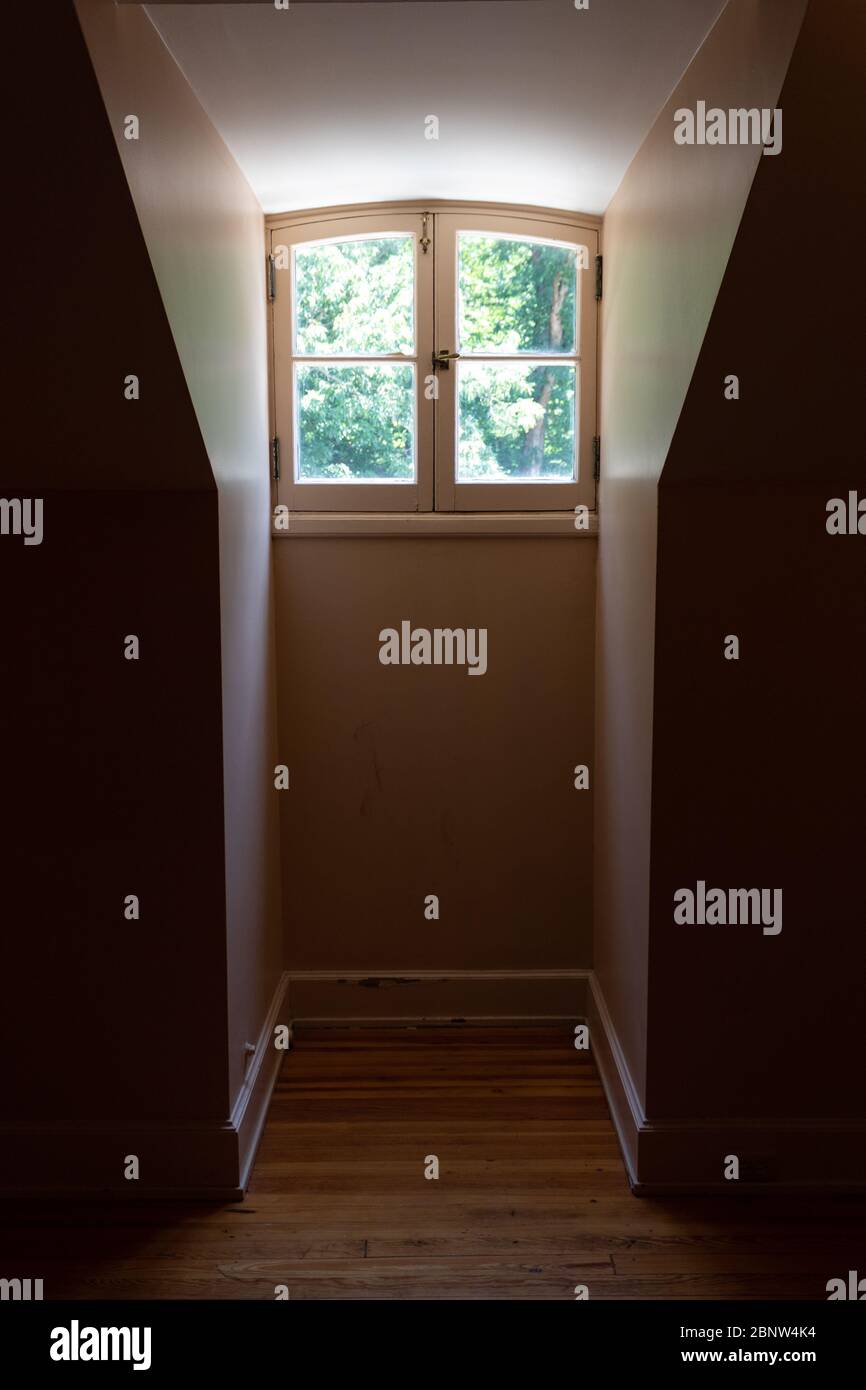 Interior view of a dormer window and very narrow opening in a darkened