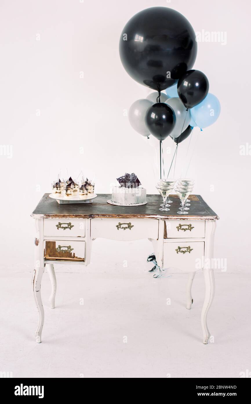 Vintage white wooden table with closets, birthday cake, desserts