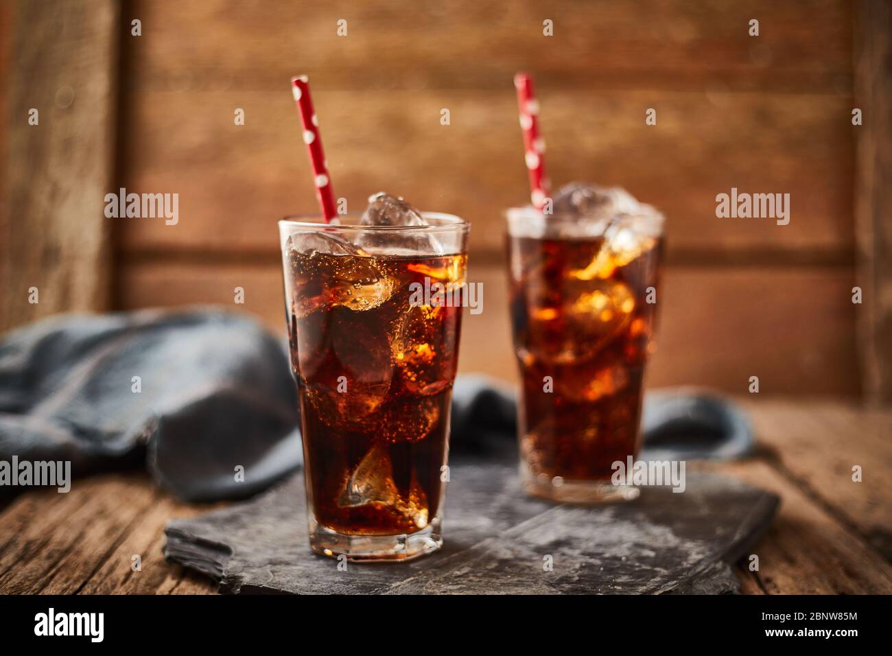 Close up glass of refreshing cola with ice on table. Stock Photo