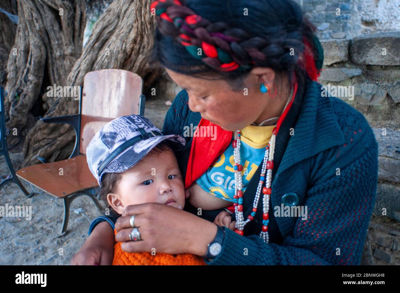 Woman breastfeeding inside Tashi Lhunpo Monastery in Shigatse Tibet