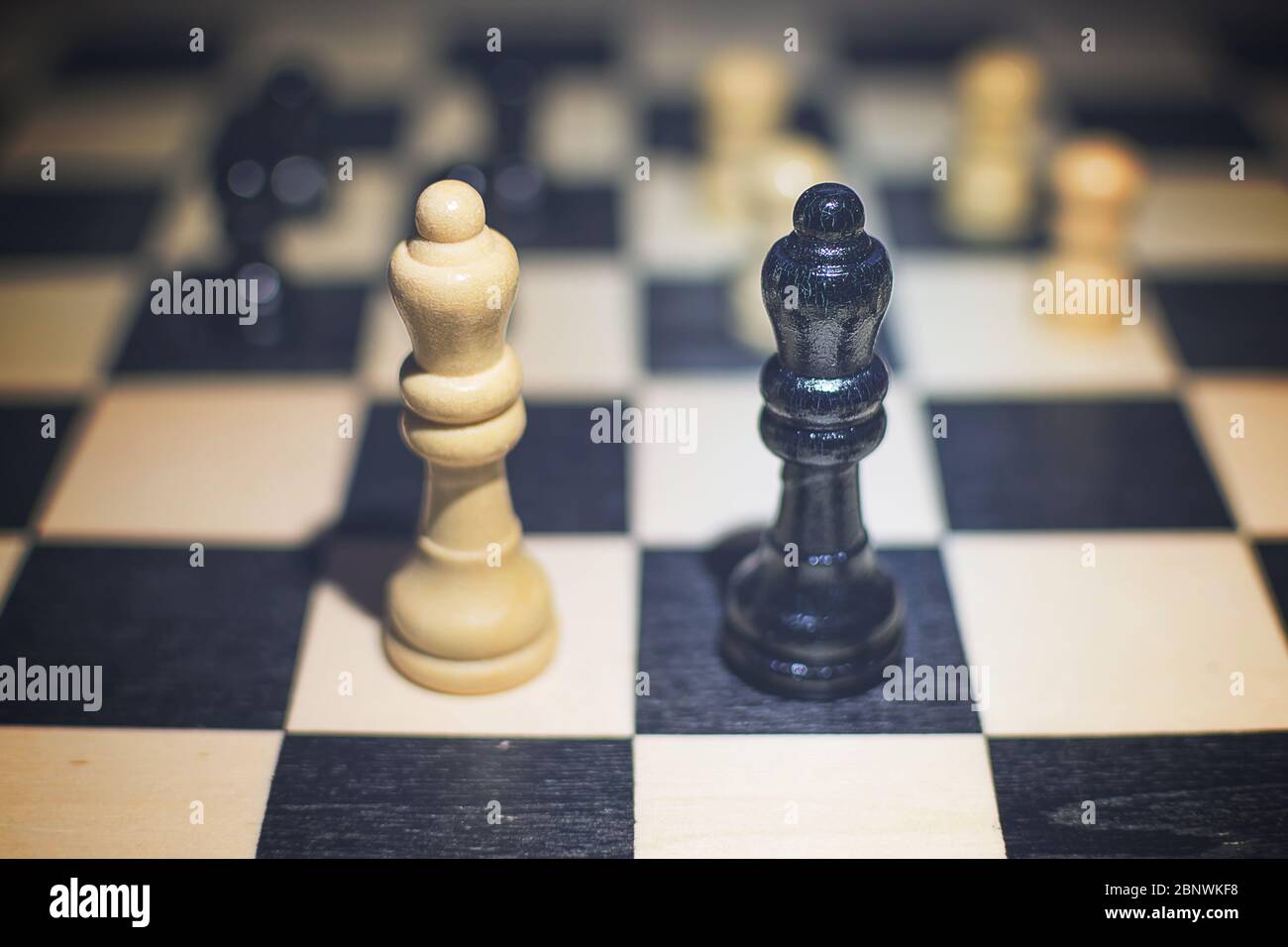 A completed chess game setup on a table with opposing chairs in a dark room  backlit by a bright window light - 3D render Stock Photo - Alamy