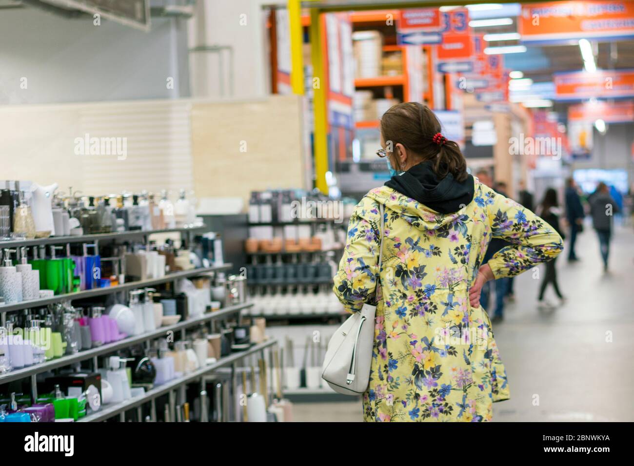 Woman in protective mask at the mall. Alarmed female wears medical mask against coronavirus while grocery shopping in supermarket, safety and pandemic Stock Photo