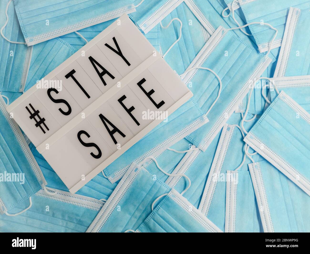 Blue surgical face masks with a white letterbox stating # Stay Safe Stock Photo