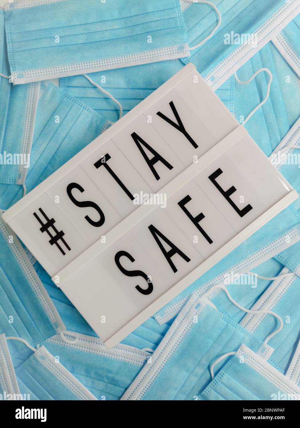 Blue surgical face masks with a white letterbox stating # Stay Safe Stock Photo