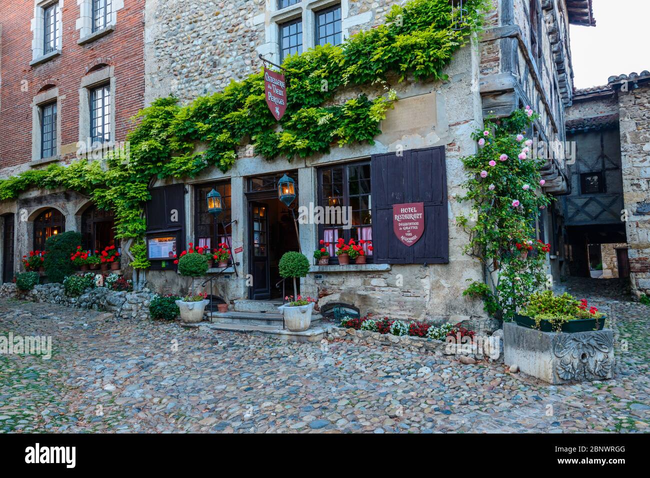 Pérouges, France: Hostellerie du Vieux Pérouges, a medieval hotel and restaurant located in several buildings around the town square Place du Tilleul. Stock Photo