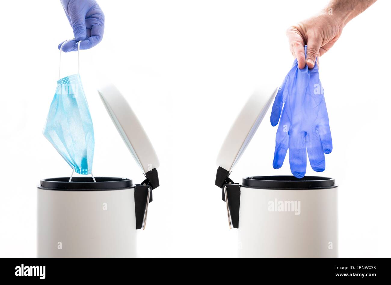 Hands throwing away a protective face mask and a used protective glove