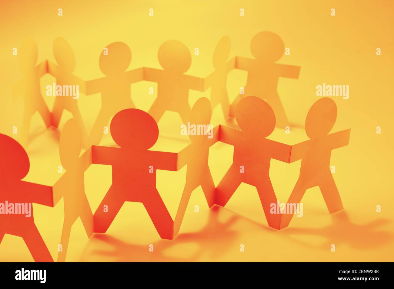 Paper chain team holding hands. Teamwork. Partnership Stock Photo - Alamy
