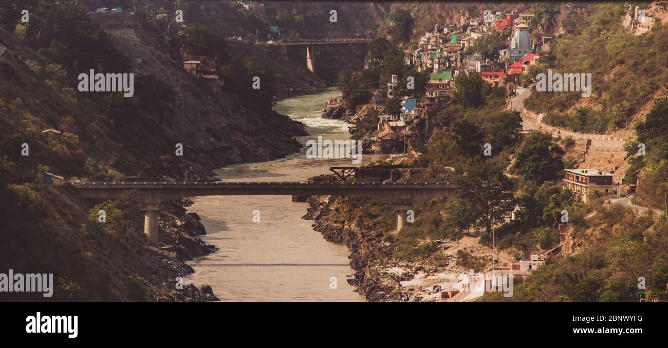 DEVPRAYAG, INDIA - JUNE 9, 2019 : The river Bhagirathi is joined by the Alaknanda river to form the Holy River of Ganges in the ancient city of Devpra Stock Photo