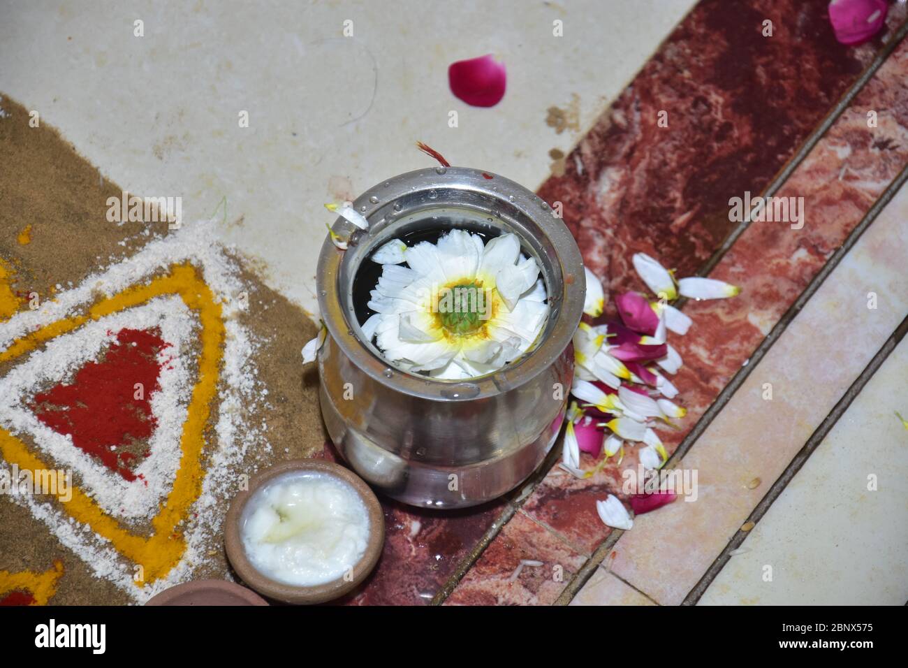 A view of a marigold flower floating in water in a steel pot Stock Photo