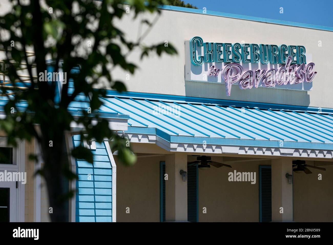 A logo sign outside of a closed and abandoned Cheeseburger in Paradise