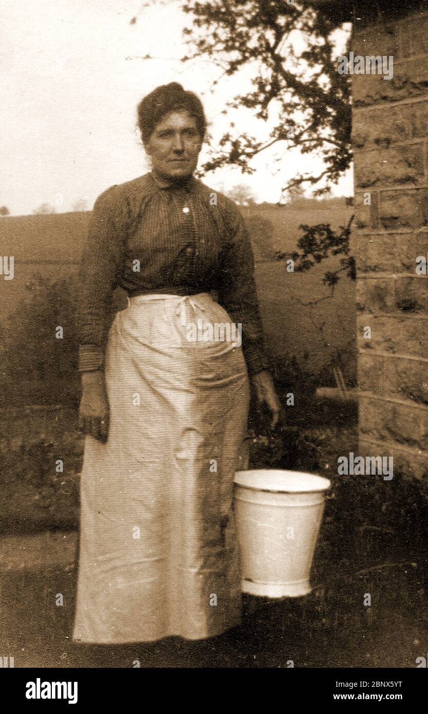 Photographic Portrait of a North Yorkshire milkmaid with her pail and apron (pinny) circa 1900 Stock Photo