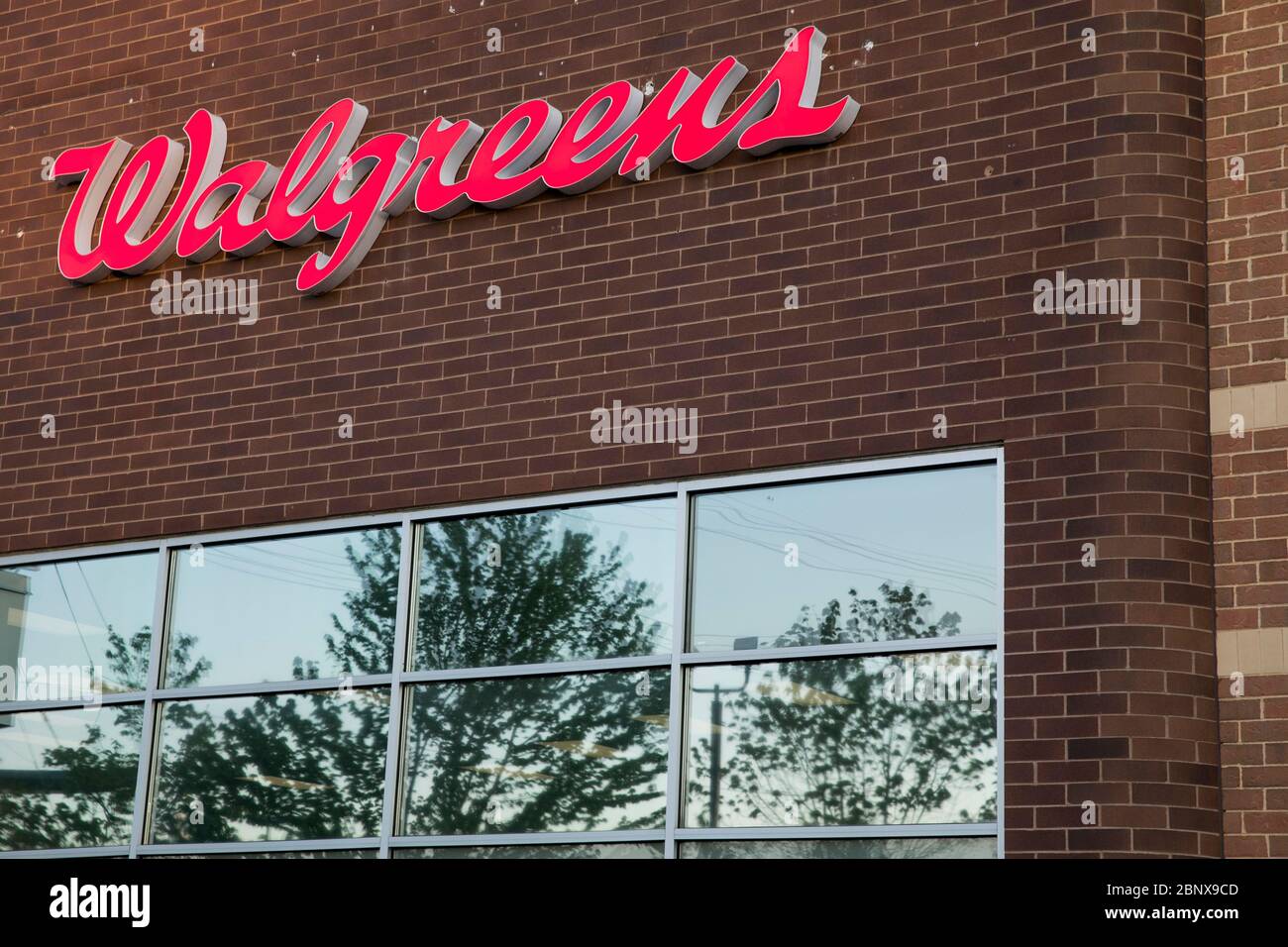 A logo sign outside of a Walgreens pharmacy location in Winchester