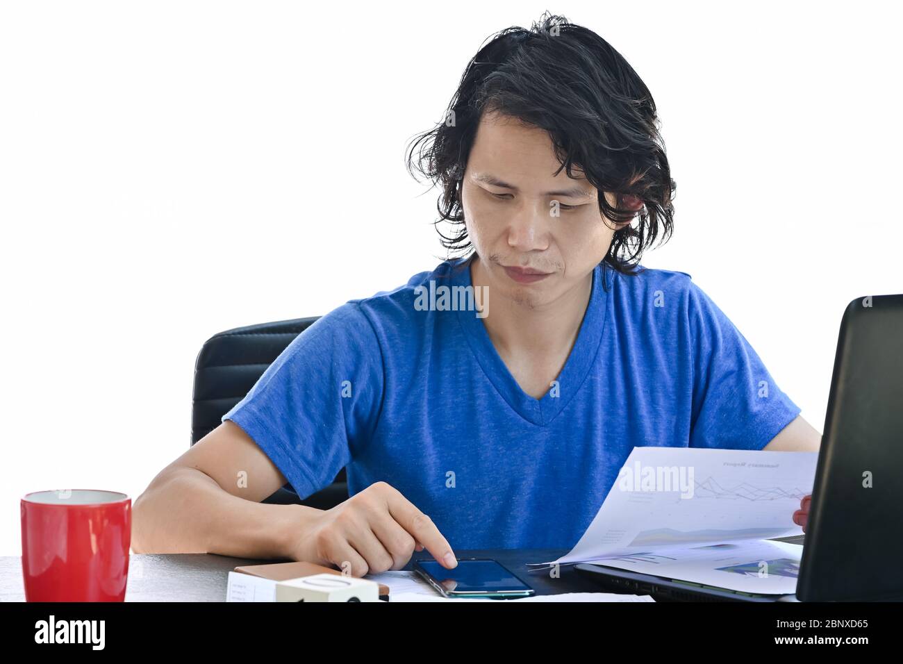 Business man calculating on calculator app on smartphone wear casual clothes working with computer and business strategy diagram at home office desk Stock Photo