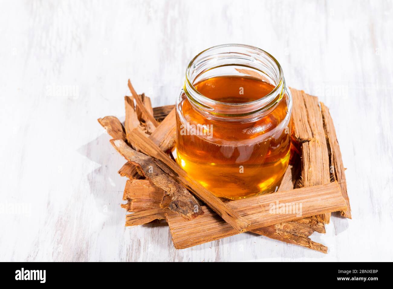 Tea and bark of cat's claw plant on wooden background, uncaria