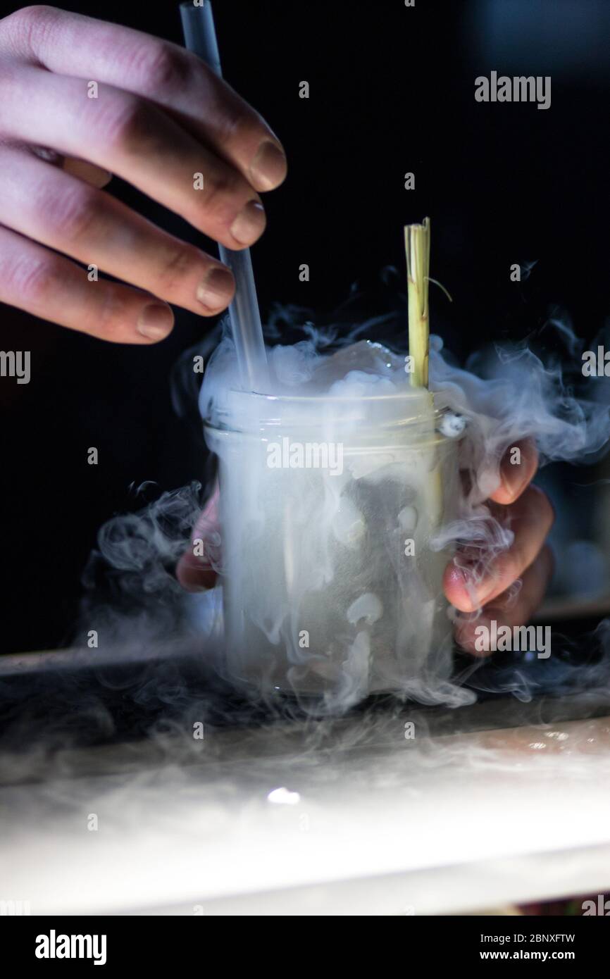 Cocktail mixing. Barkeeper pouring gin. Mixing drinks on event Stock