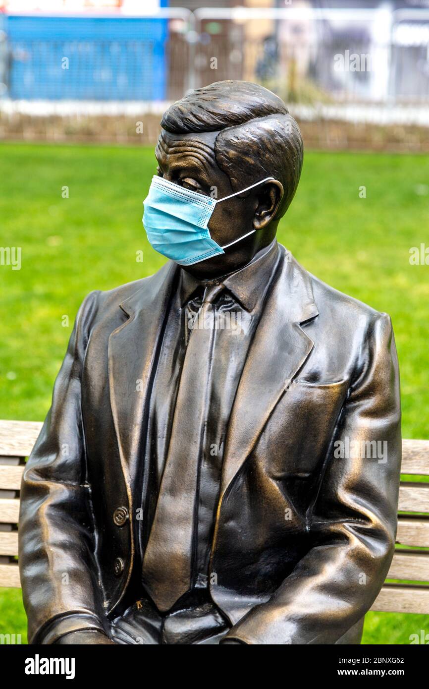 16 May 2020 London, UK - Statue of Mr Bean sitting on a bench wearing a protective face mask in Leicester Square during the coronavirus pandemic lockdown Stock Photo