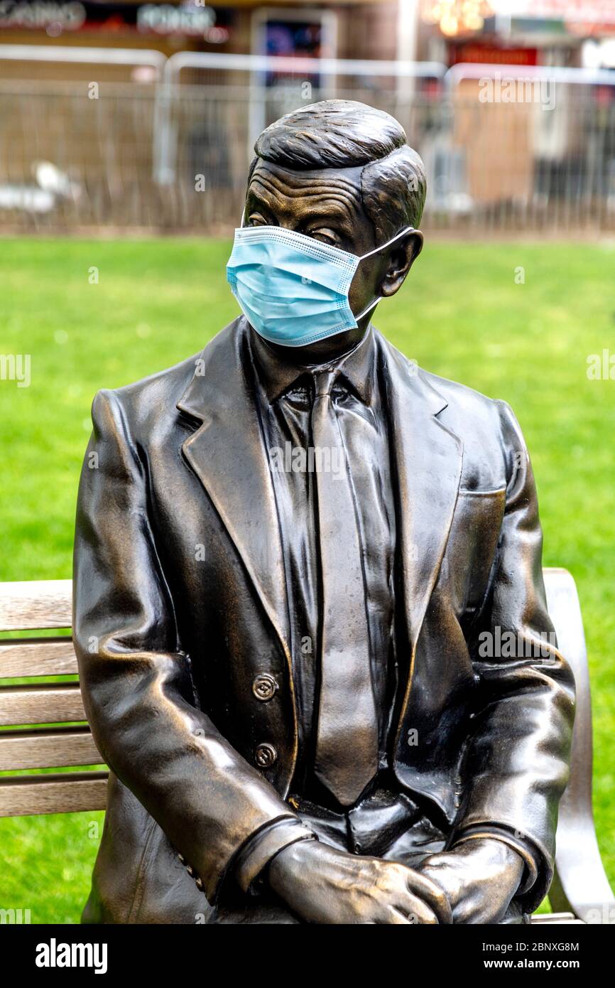 16 May 2020 London, UK - Statue of Mr Bean sitting on a bench wearing a protective face mask in Leicester Square during the coronavirus pandemic lockdown Stock Photo