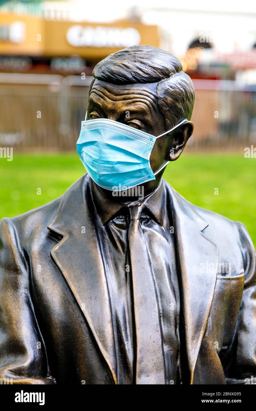 16 May 2020 London, UK - Statue of Mr Bean sitting on a bench wearing a protective face mask in Leicester Square during the coronavirus pandemic lockdown Stock Photo