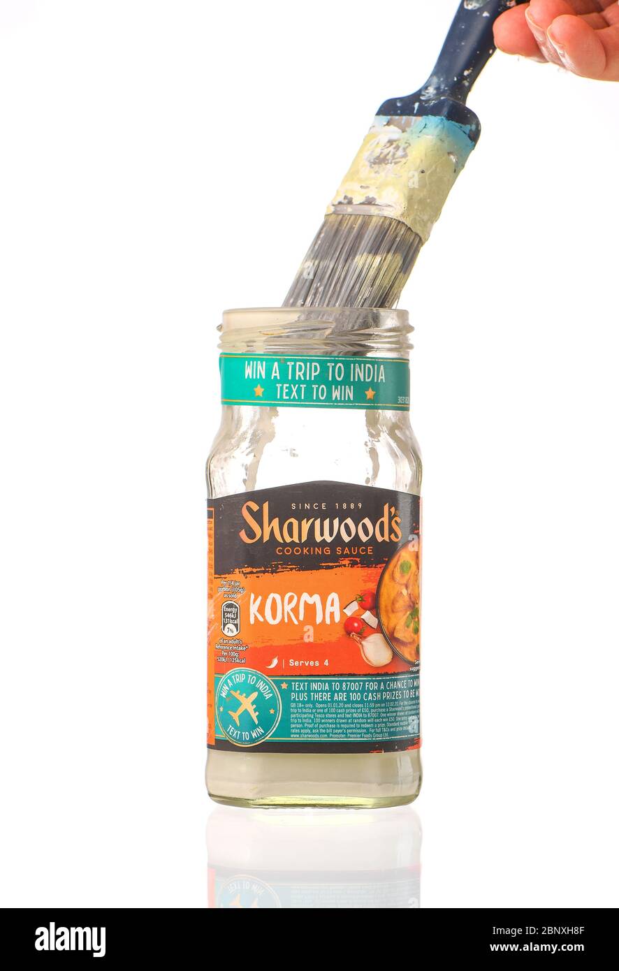 A Sharwoods cooking sauce pot used as a paint brush cleaner container as part of recycling use of products and glass.  isolated on a white background. Stock Photo