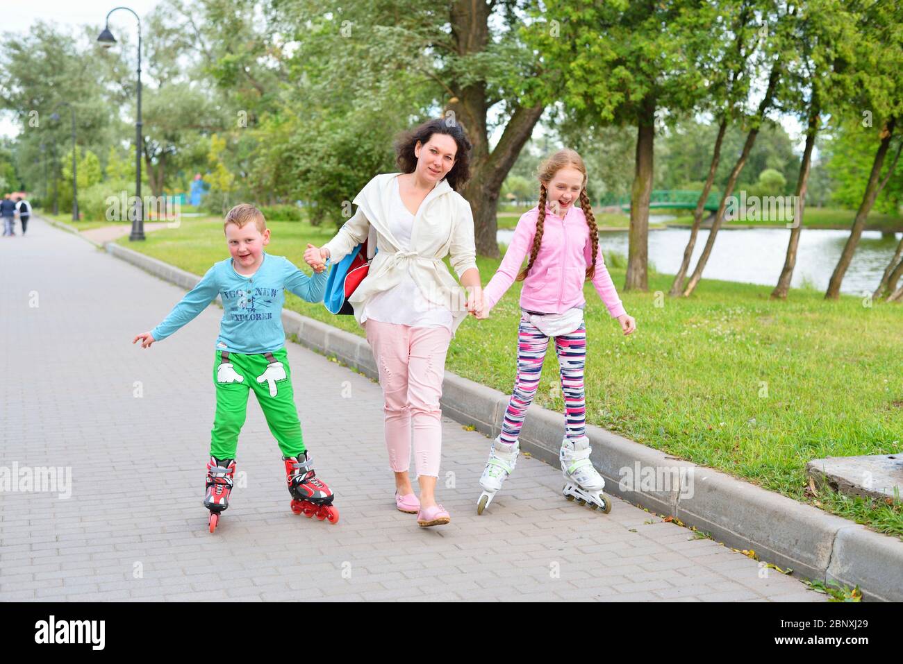 Sports family-mother with children on roller skates in the Park Stock Photo