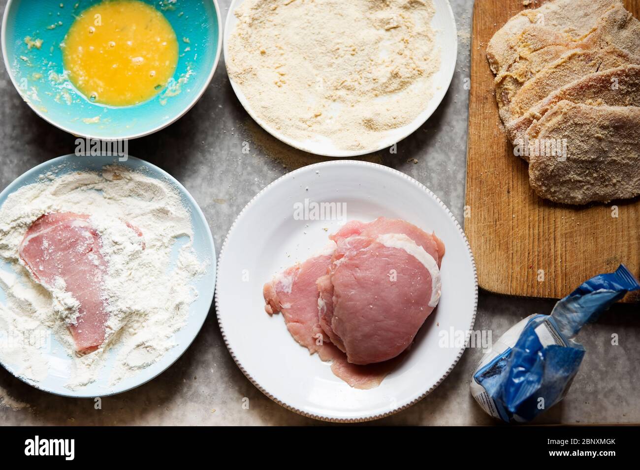 Preparing breaded pork chops, polish kotlety. Flour, whisked egg, bread