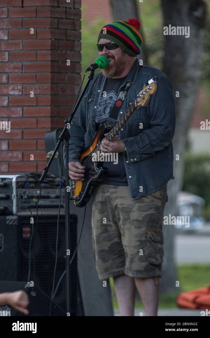 Bass player, in rock and roll band, performing at outdoor concert Stock Photo