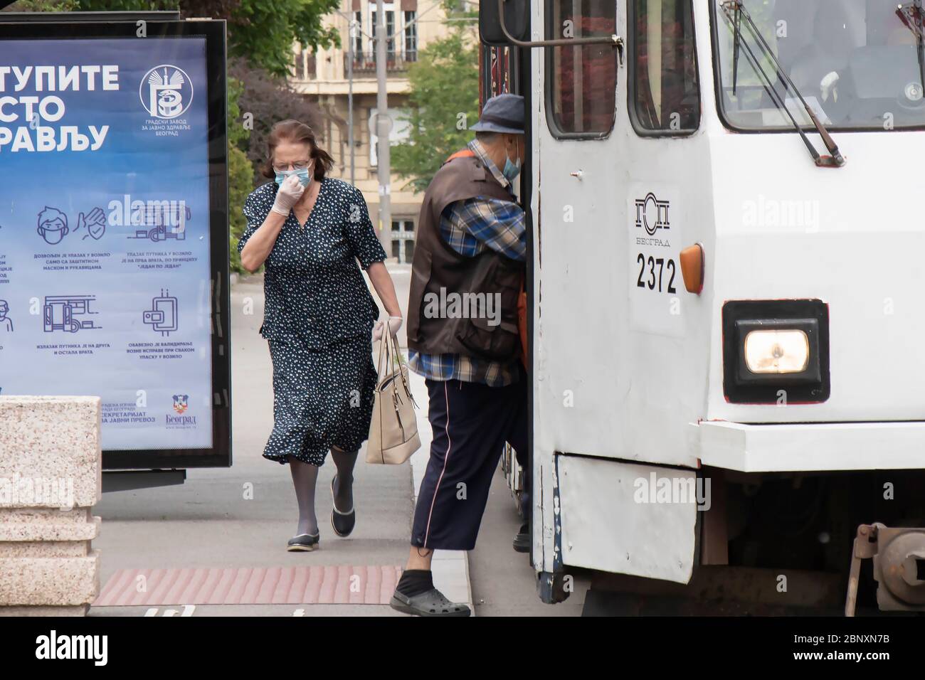 Belgrade, Serbia - May 12, 2020: Elder people wearing face surgical masks and gloves getting in the public transportation Stock Photo