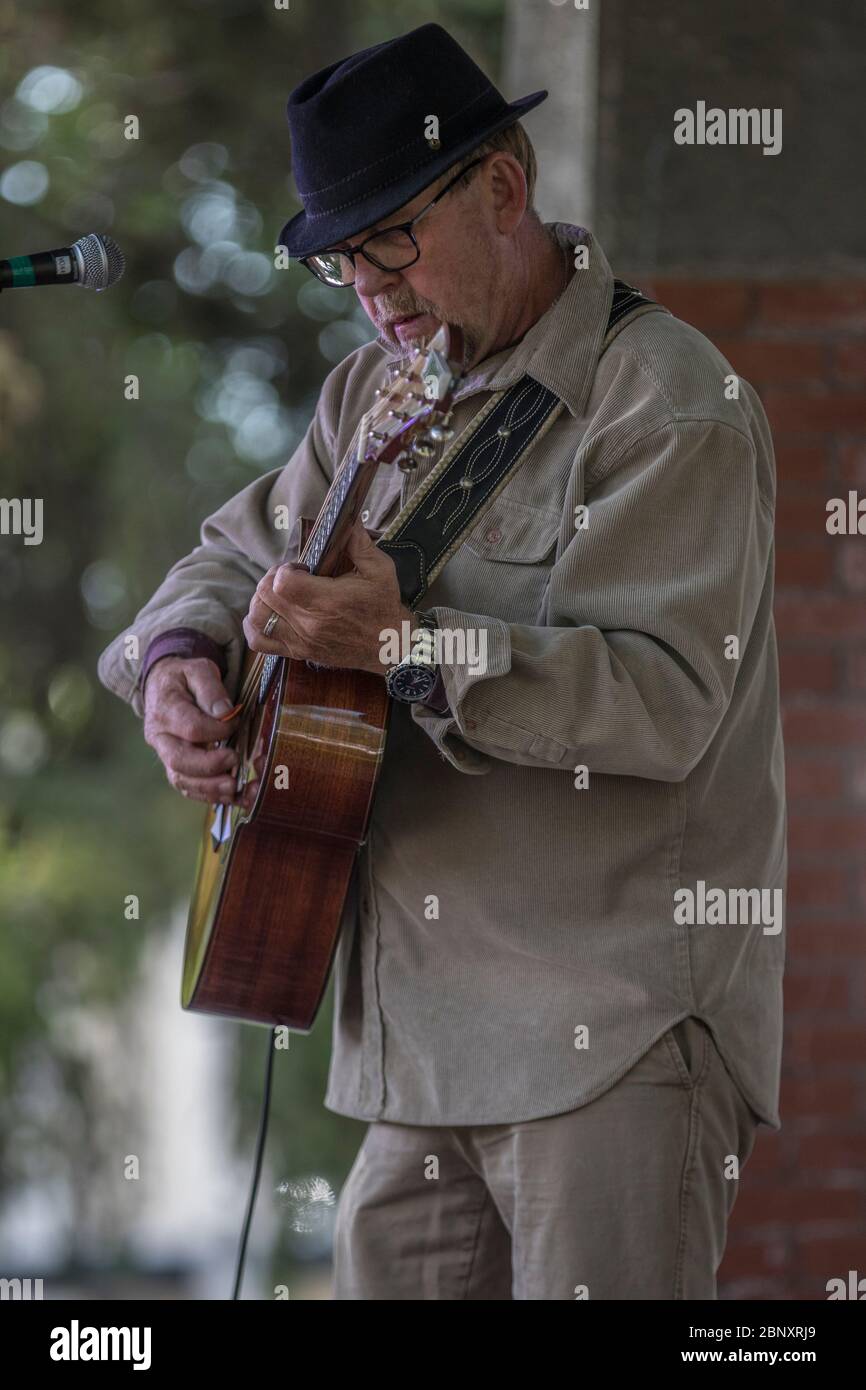 Folk singer performing at oudoor concert. Singing and playing guitar Stock Photo