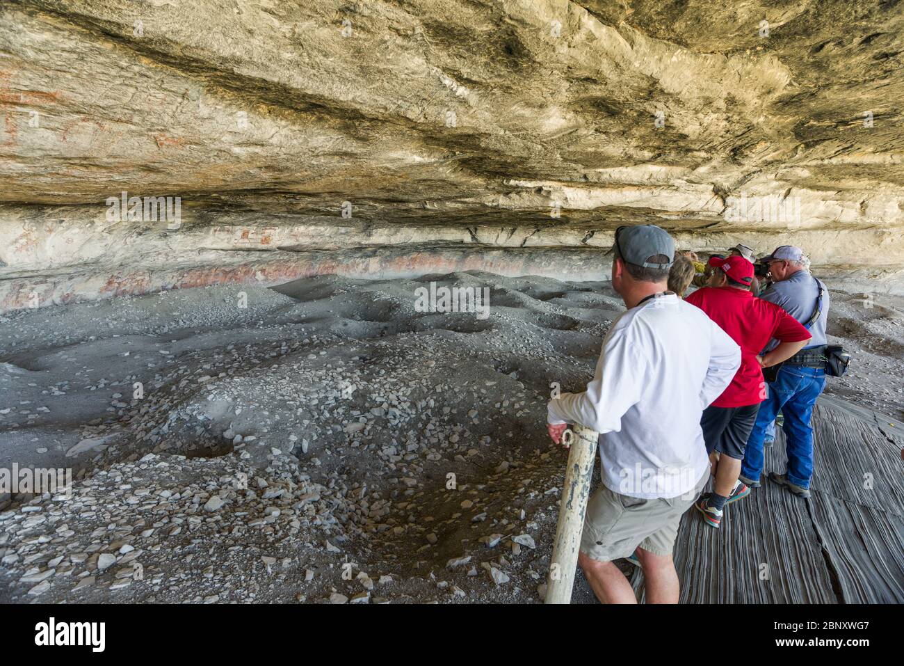 Tourists looking at the various Navajo wall painting pictographs at Fate Bell Shelter, within Seminole Canyon, Texas Stock Photo