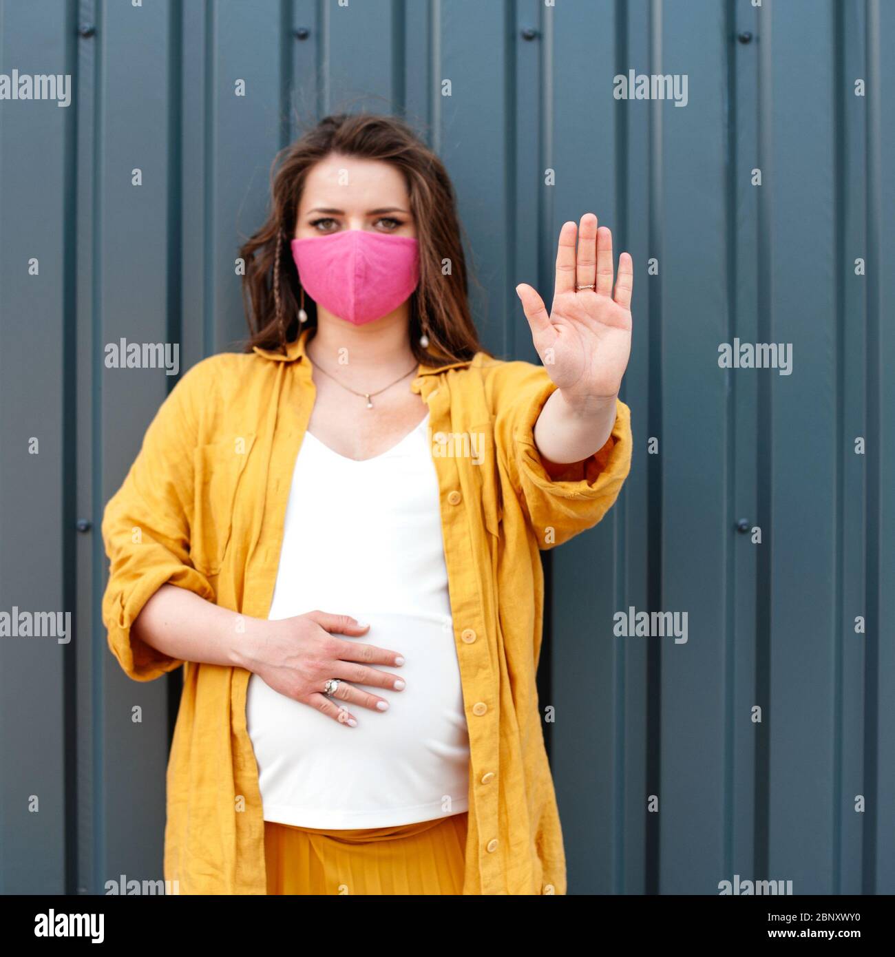 Download Pregnant Woman In A Protective Mask And Yellow Clothes On A Blue Wall Background The Concept Of Social Distance Soft Focus Stock Photo Alamy Yellowimages Mockups