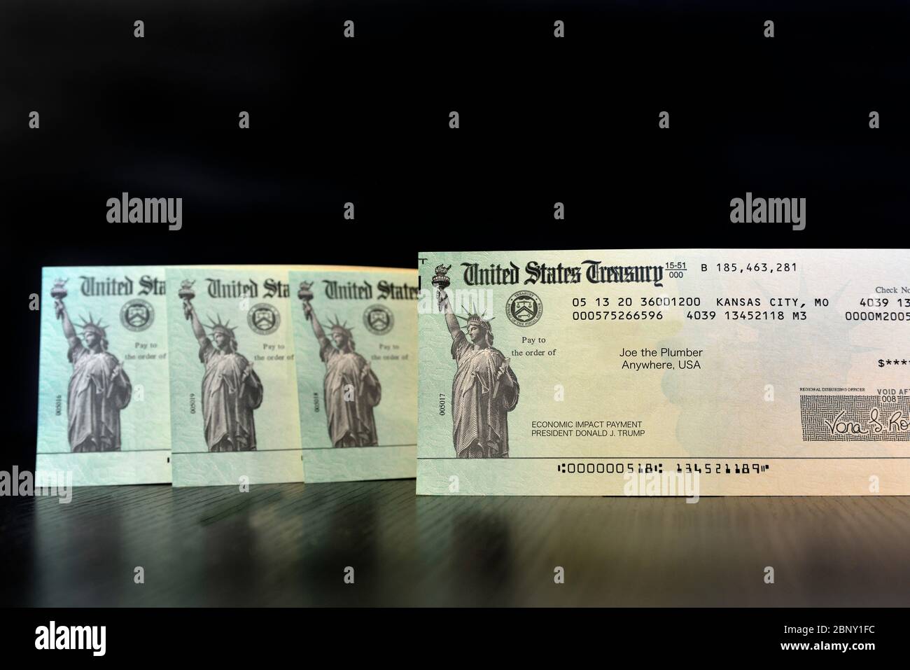 A standing upright row of United States Treasury Checks, payment for Economic impact from President Donald Trump, made payable to Joe the Plumber, iso Stock Photo