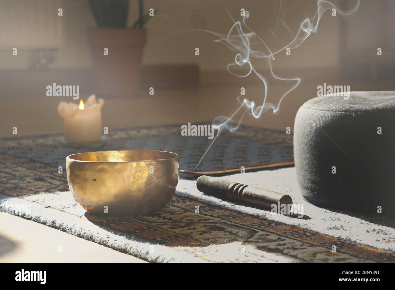 meditation room with singing bowl, incense stick, smoke, pillow and