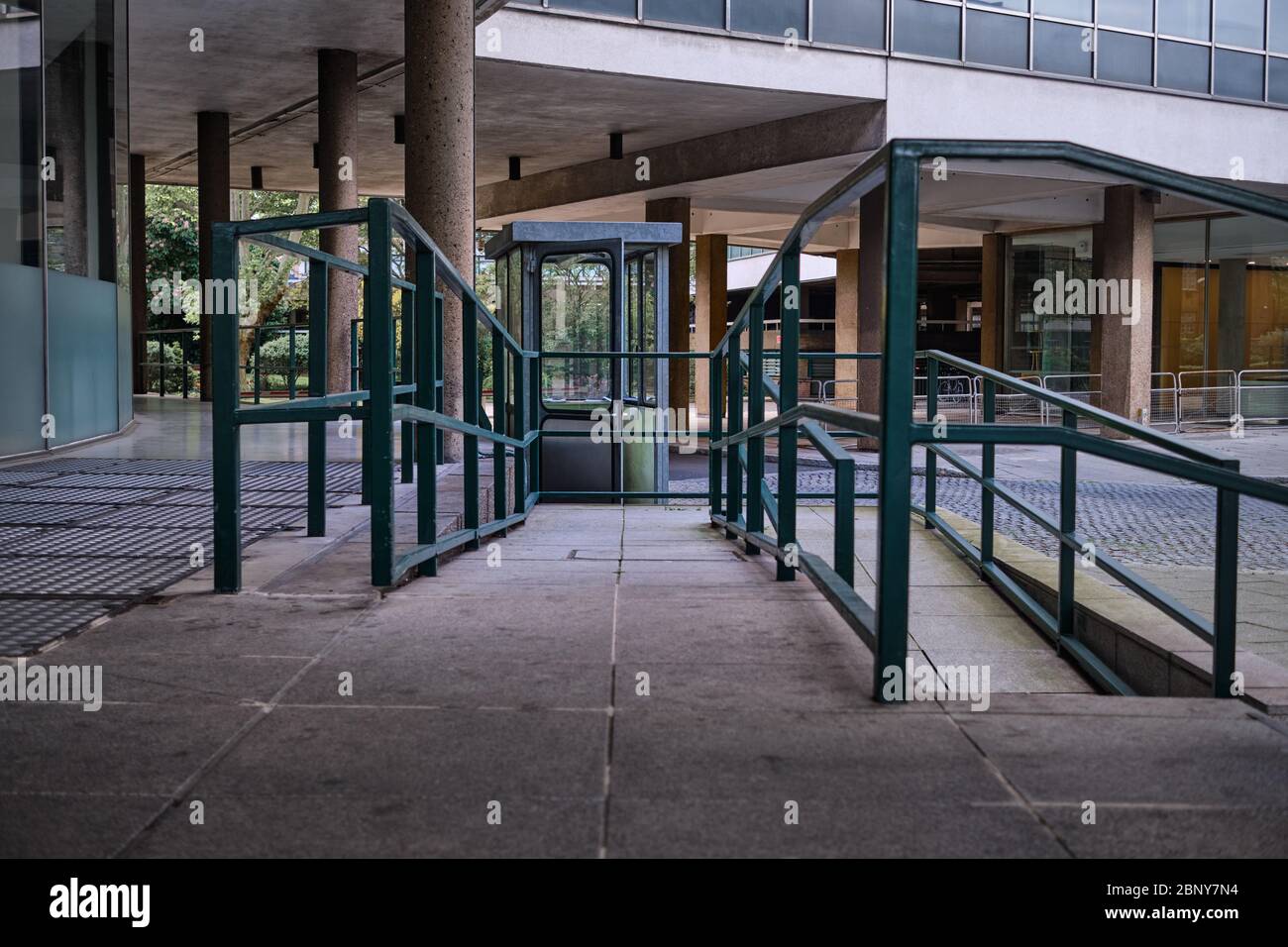 Green metal railings along ramp in 60s office development Stock Photo