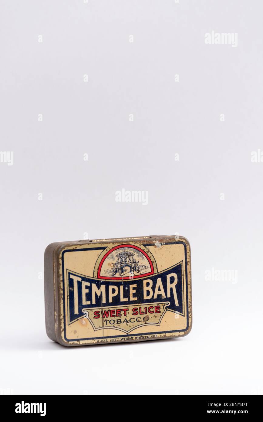 A still life studio image on a white background of an antique tobacco tin with the Temple Bar sweet slice logo painted on it Stock Photo