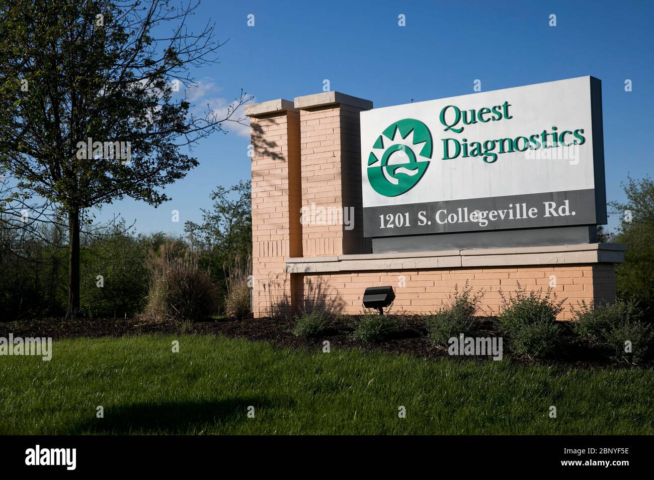 A logo sign outside of a facility occupied by Quest Diagnostics in