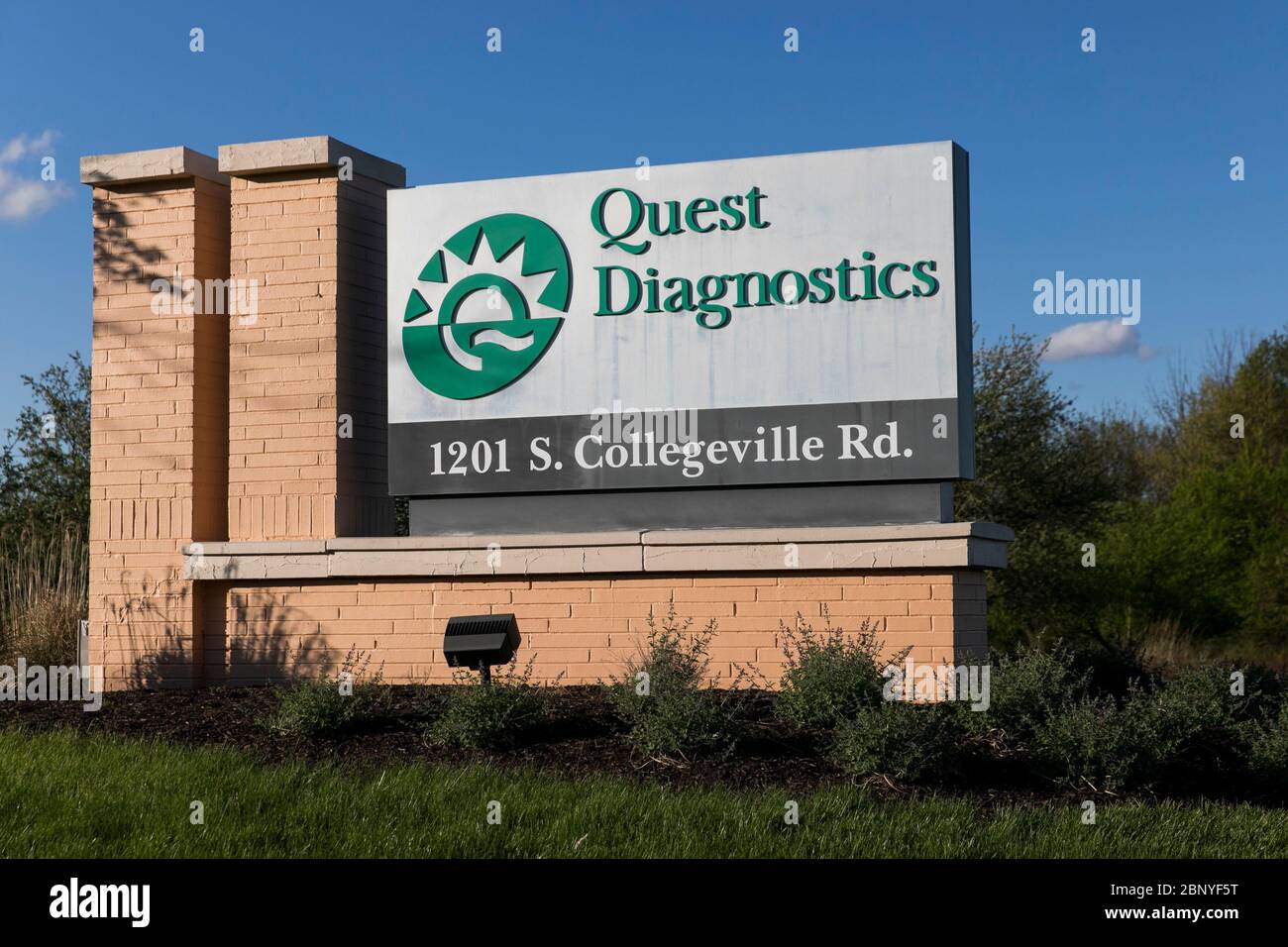 A logo sign outside of a facility occupied by Quest Diagnostics in