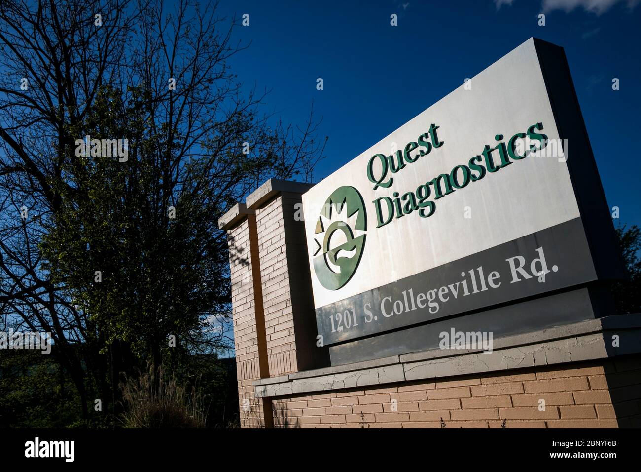 A logo sign outside of a facility occupied by Quest Diagnostics in
